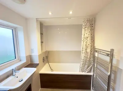 a bathroom with a bath tub and a sink at Spacious 6-Bed Detached Home in Chigwell in Friern Barnet