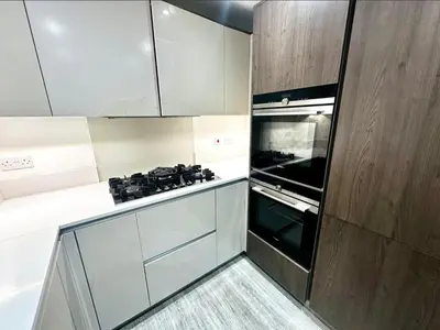a kitchen with white cabinets and a stove top oven at Spacious 6-Bed Detached Home in Chigwell in Friern Barnet