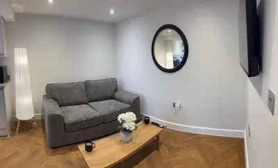 a living room with a couch and a mirror at Little Dunton Lodges 2 in Brentwood