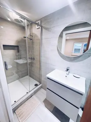 a bathroom with a shower and a sink and a mirror at Little Dunton Lodges 2 in Brentwood