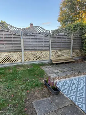 a wooden fence with a bench in a yard at The Wright Place To stay in East Harling