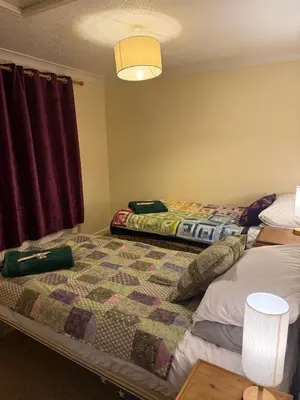 a bedroom with two beds and a quilt at The Wright Place To stay in East Harling