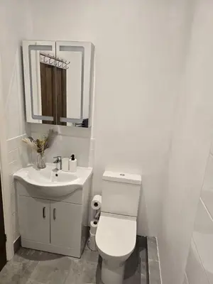 a white bathroom with a toilet and a sink at Coastal Comfort in Leigh Ideal for Work & Leisure in Southend-on-Sea