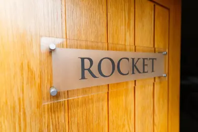 a wooden door with a rockett sign on it at Chippenham Park Garden Rooms in Chippenham