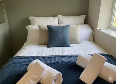 a bed with two piles of towels on it at Easy walk to Addenbrookes - Stylish 1 bedroom Apartment in CBG