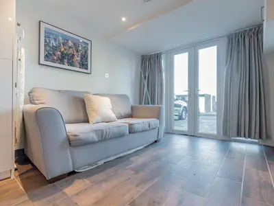 a living room with a couch and a large window at Pass the Keys Cosy Studio in Basildon Sleeps up to 4 in Basildon
