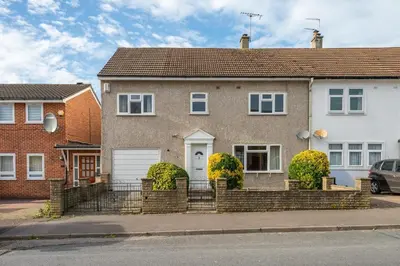 a house with a fence in front of it at Serene 5BR - A Cozy Home Away From Home in Theydon Bois
