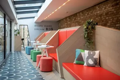 a lobby with a bench and a table and a sign at For Students Only - Student Castle Cambridge in Cambridge