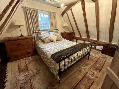 a bedroom with a bed with pillows on it at Beautiful Cottage opposite Hedingham Castle! in Castle Hedingham