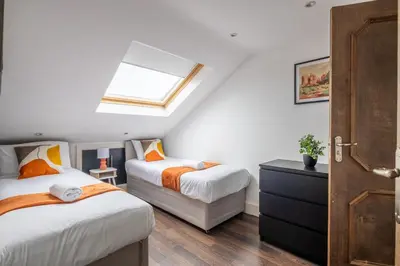 a attic bedroom with two beds and a skylight at 4 BR I 2 BA I Sleeps 8 I Spacious I Modern I Wi-Fi I in Cambridge