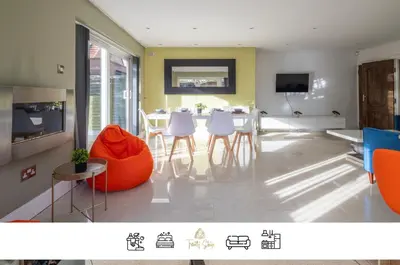 a living room with a table and chairs and a tv at 4 BR I 2 BA I Sleeps 8 I Spacious I Modern I Wi-Fi I in Cambridge