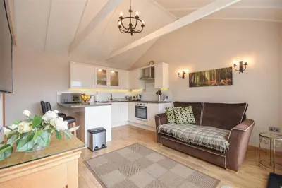 a living room with a couch and a kitchen at The Barn in Little Maplestead