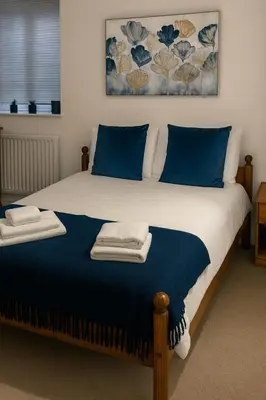 a bedroom with a bed with blue pillows at The Little Nest in Colchester in Colchester