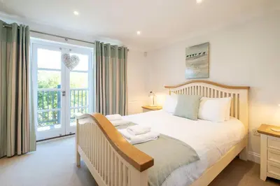 a bedroom with a large bed and a window at 7 Sanctuary Court - sleeps 12 - Thorpeness - Aldeburgh Coastal Cottages - Close to the Beach, Golf and the Country Club in Thorpeness