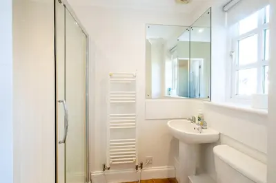 a white bathroom with a sink and a shower at 7 Sanctuary Court - sleeps 12 - Thorpeness - Aldeburgh Coastal Cottages - Close to the Beach, Golf and the Country Club in Thorpeness