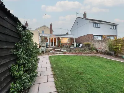 a house with a lawn in front of it at Berkley Cottage in Colchester