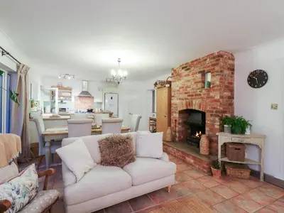 a living room with a white couch and a fireplace at Berkley Cottage in Colchester