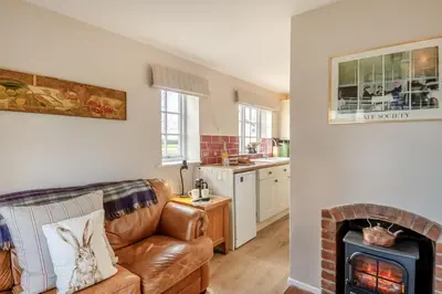 a living room with a couch and a fireplace at 2 Bed in Bressingham oc-f33646 in Bressingham