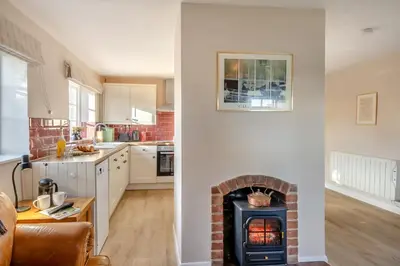 a kitchen and a living room with a brick fireplace at 2 Bed in Bressingham oc-f33646 in Bressingham