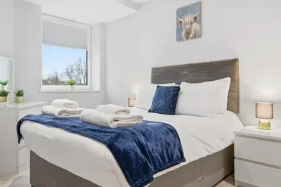 a bedroom with a large bed with towels on it at Heart of Brentwood - 1 Bed - Underground Parking - Fast Wifi in Brentwood