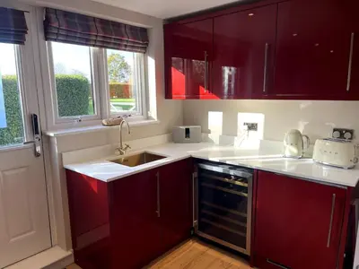 a kitchen with red cabinets and a sink at Greenfinch Lodge