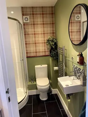 a bathroom with a toilet and a sink and a mirror at Greenfinch Lodge