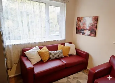 a red couch in a living room with a window at Modern 4BR Cambridge House with Parking for 9 guests in Cambridge