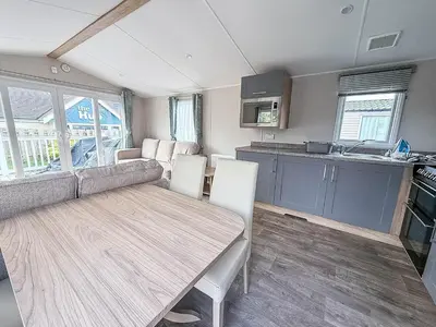 a kitchen and dining room with a table in a caravan at Spacious 8 Berth Caravan With Decking At Naze Marine In Essex Ref 17012Rd in Walton-on-the-Naze