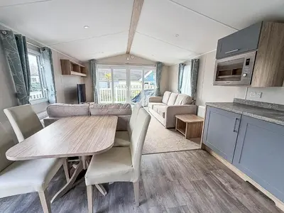 a kitchen and living room with a table and chairs at Spacious 8 Berth Caravan With Decking At Naze Marine In Essex Ref 17012Rd in Walton-on-the-Naze