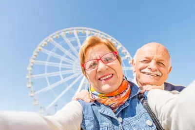 an older couple standing in front of a ferris wheel at Spacious 8 Berth Caravan With Decking At Naze Marine In Essex Ref 17012Rd in Walton-on-the-Naze