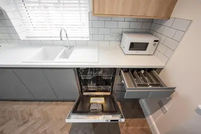 a kitchen with a sink and a microwave at 5 The Royal Serviced Apartments Harwich, Private Parking, Fast Wifi in Parkeston