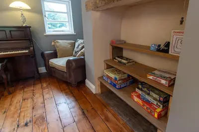 a living room with a couch and a piano at The Manor Dairy in Sandy