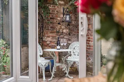 a table and chairs on a patio with a brick wall at Bridewell Lane, Bury St Edmunds, Suffolk in Bury Saint Edmunds