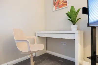 a desk and a chair in a room at Modern Comfort, Free Parking, Netflix & Disney plus in every Bedroom and Living Room in Shephall