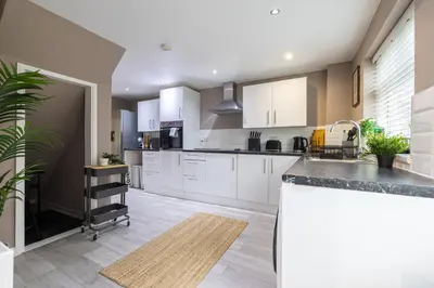 a kitchen with white cabinets and a counter top at Modern Comfort, Free Parking, Netflix & Disney plus in every Bedroom and Living Room in Shephall