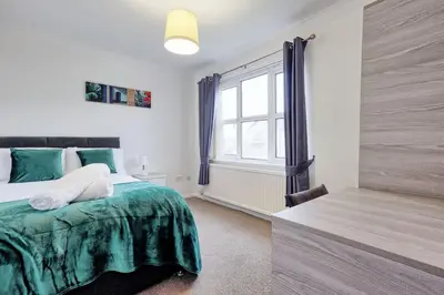 a bedroom with a bed and a window at Surehaven Stays 6 Bedroom House Great for Teams in Colchester