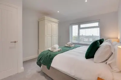 a bedroom with a large bed with towels on it at Surehaven Stays 3 Bedroom House Braintree in Braintree