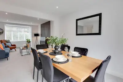 a dining room with a wooden table and chairs at Surehaven Stays 3 Bedroom House Braintree in Braintree