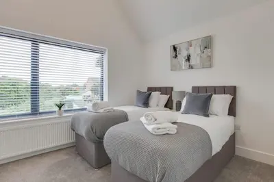 a bedroom with two beds and a window at Surehaven Stays 4 Bedroom House Braintree in Braintree