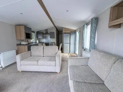 a living room with two couches and a kitchen at Lovely 8 Berth Caravan With Decking To Hire At Naze Marine In Essex Ref 17030Ga in Walton-on-the-Naze