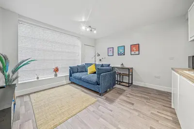 a living room with a blue couch and a table at College Lane Apartment, Bury St Edmunds in Bury Saint Edmunds
