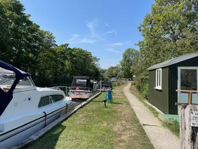a boat is docked on a canal with other boats at Riverside Retreat in Little Baddow