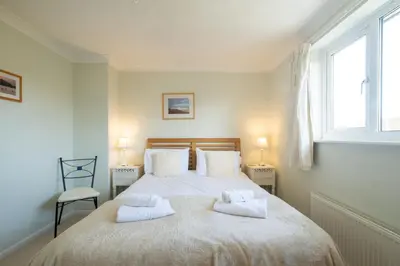 a bedroom with a bed with two towels on it at Rainbow Cottage in Thorpeness, Close to the Beach, Golf and the Country Club in Thorpeness