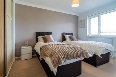 two beds sitting next to each other in a bedroom at Spacious 3-Bed Home with parking in Lexden