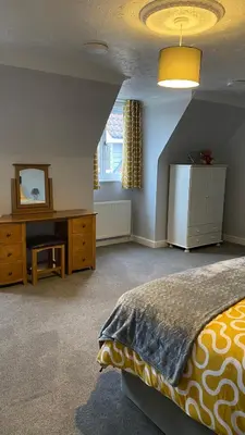a bedroom with a bed and a desk and a window at The cottage in Bury Saint Edmunds