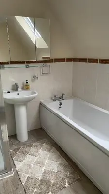 a bathroom with a white tub and a sink at The cottage in Bury Saint Edmunds
