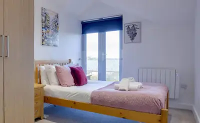 a bedroom with a bed with pillows and a window at Stylish and Modern Flat with Free Parking - Pass the Keys in Cambridge