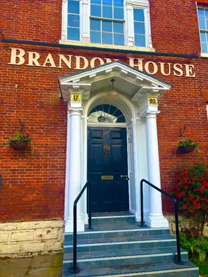 a front door of a brick building with a blue door at Brandon House in Brandon