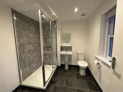 a bathroom with a shower and a toilet and a sink at Brandon House in Brandon