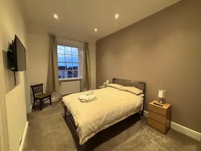 a bedroom with a bed and a chair and a window at Brandon House in Brandon